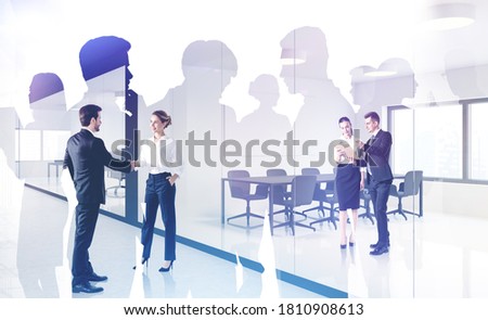 Business people shaking hands in meeting room with double exposure of their business team. Toned image