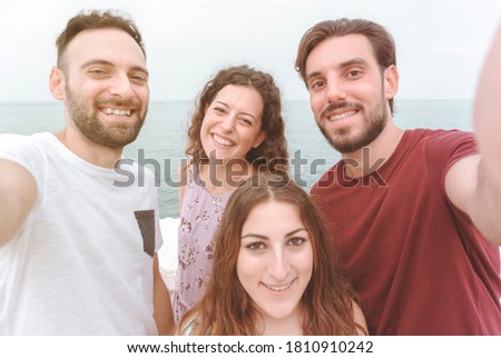 Friends group on vacation take a selife - happy people enjoy their weekend off taking a photograph