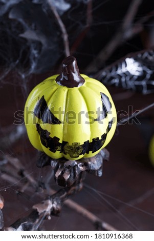 Creative painted laughing Halloween pumpkin against dark background.