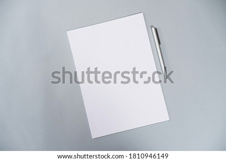 White paper and pen on gray table flat lay stock photo