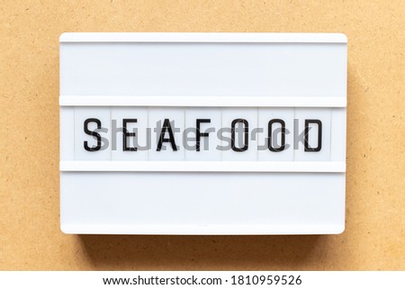 Lightbox with word seafood on wood background