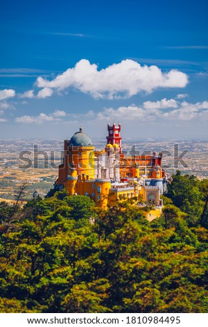 Famous historic Pena palace part of cultural site of Sintra against sunset sky in Portugal. Panoramic View Of Pena Palace, Sintra, Portugal. Pena National Palace at sunset, Sintra, Portugal.  Royalty-Free Stock Photo #1810984495