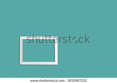 Minimalistic style. A white blank picture frame on an neo mint background , flat lay.