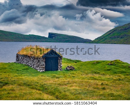 Lonely turf-top houses on the coast of Sorvagsvatn lake, Vagar island. Gloomy morning view of Faroe Islands, Denmark, Europe. Traveling concept background.