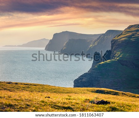 High cliiffs on the shore of Atlantic Ocean. Amazing summer view of Faroe Islands, Denmark, Europe. Exciting morning seascape. Beauty of nature concept background.
