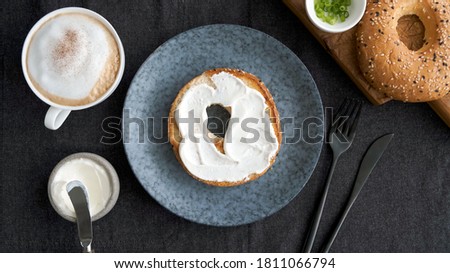 Toasted bagel with cream cheese and cup of coffee for breakfast, top view Royalty-Free Stock Photo #1811066794