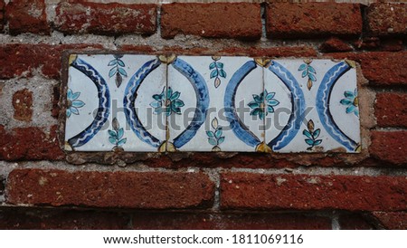 decorative tiles against red brick wall background