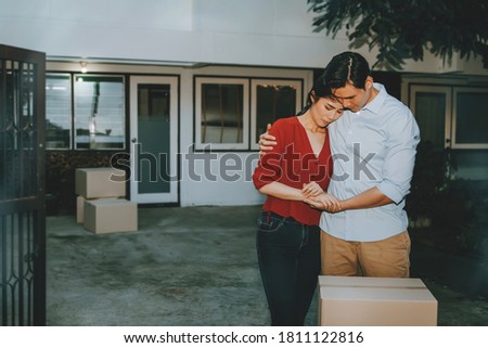 Concept House sales and relocation : Unhappiness of couples who had to move out of their homes sadly due to financial problems and the recession. Royalty-Free Stock Photo #1811122816