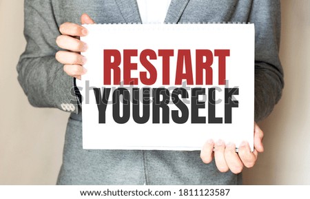 businessman holding a card with text RESTART YOURSELF