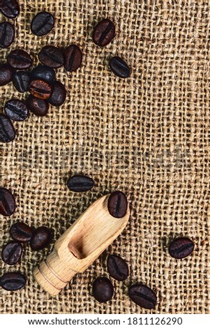 Coffee beans. Macro photo Burlap fabric. Wooden spoon for coffee. Rough fabric texture. Fabric Canvas. Coffee beans on sacking. Coffee abstraction.