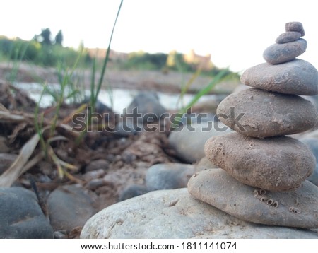 Picture of a pebble near a valley with a reed in the background