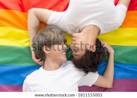 Male couples with Asian men sleep on a multicolored flag with an LGBT logo showing openly gay men accepting LGBT concepts.