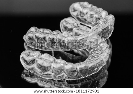 Invisible transparent dental removable braces on the black background. Orthodontic appliance for dental correction. Aligners for teeth straightening. Royalty-Free Stock Photo #1811172901