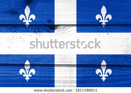 quebec flag painted on old wood plank background. Brushed natural light knotted wooden board texture. Wooden texture background flag of quebec