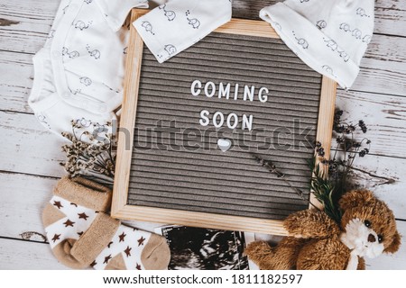 Coming soon sign. Baby announcement sign on a rustic white background. Coming soon concept.  Royalty-Free Stock Photo #1811182597