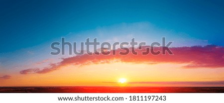 Colorful cloudy sky at sunset over the countryside. Gradient color. 