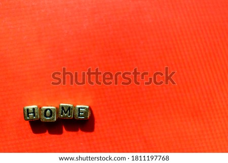 Abstract house lettering on red backdrops. An inscription made from golden cubes. View from above