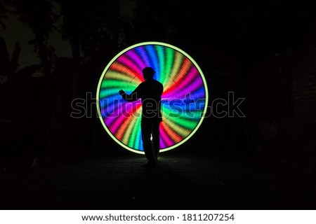 One people standing alone against a incredible of circle light painting as the backdrop