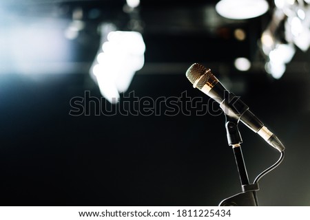 The microphone connected with cable on abstract blurred of light in the studio, speaking conference hall light or podcast recording. Event Background. Copy space on the left.