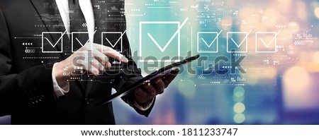 Checklist concept with businessman using his tablet computer Royalty-Free Stock Photo #1811233747