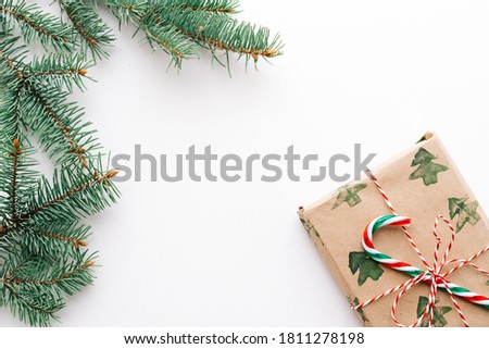 Christmas composition. Gifts, fir branches, red and green Christmas candies, decorations on a white background. The concept of Christmas, winter, New year. Flat layout, top view, copy space.