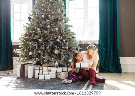 picture of mother and daughter with gift boxes, christmas