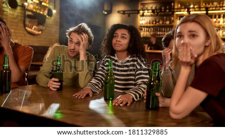 Friends looking unhappy while watching sports match on TV together, drinking beer and cheering for team in the bar. People, leisure, friendship and entertainment. Web Banner