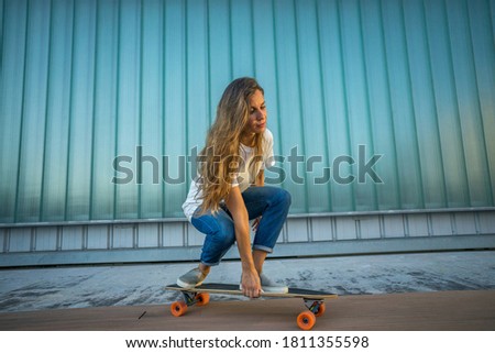 woman in white t-shirt and jeans skateboarding