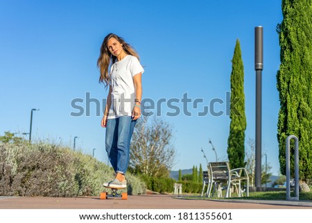 woman in white t-shirt and jeans skateboarding