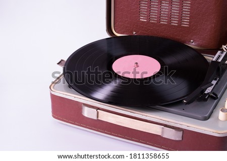 Old record player and vinyl record on a white background