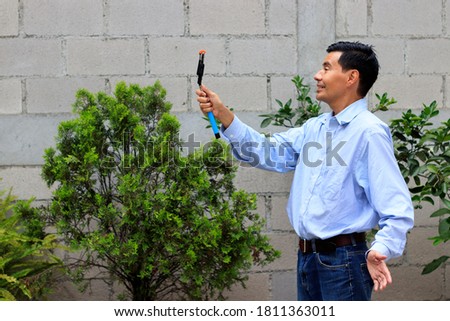 man recording a vlog or taking a selfie with cellphone and selfie stick