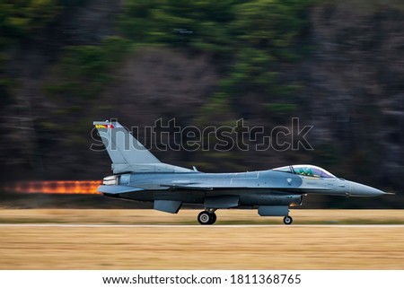 A fighter jet at full afterburner during take off. Royalty-Free Stock Photo #1811368765