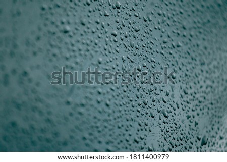 A flat blue background with a lot of water drops and out of focus surroundings