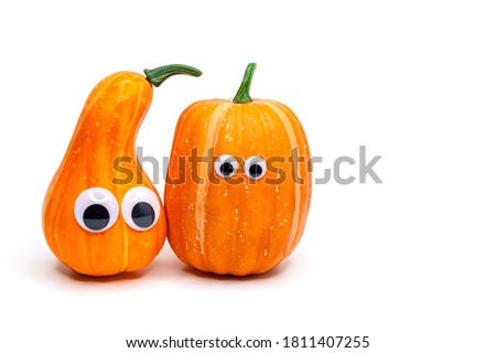 Two cute decorative pumpkins with eyes on an isolated white background. Thanksgiving and halloween day concept
