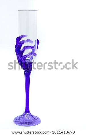 Cool Novelty Wine Glass with Transparent Purple Skeleton Wrist and Hand making up the Stem and Gripping Bowl. Halloween party celebration concept. 