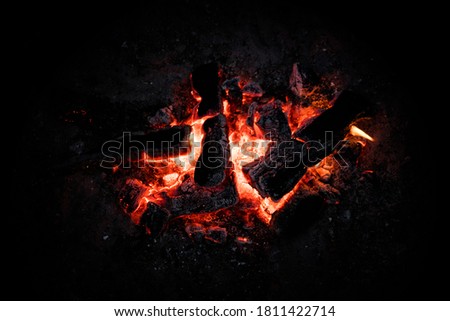 Red Hot Coals Glowing on a Dying Campfire Pit. Orange Glow from Embers on a Fire at Night