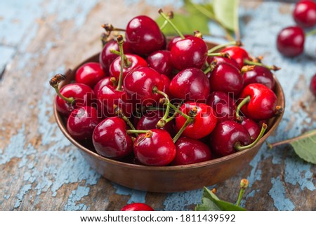 cherry in bowl on rusty blue background Royalty-Free Stock Photo #1811439592