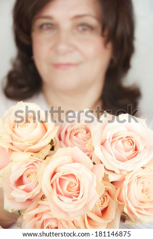 Woman holds a huge bouquet of pastel roses