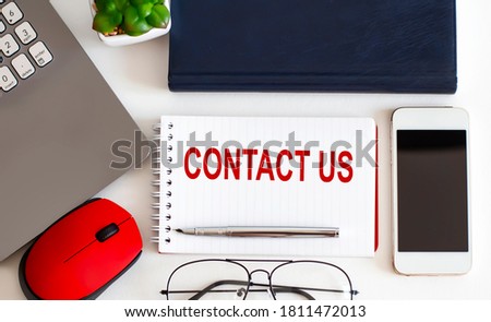 CONTACT US text with fountain pen, decorative plant, keyboard and notepad on wooden background. Business concept