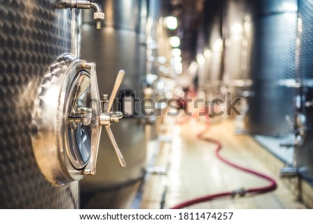 Metal vats for fermentation. Wine factory. Steel barrels in winery. Royalty-Free Stock Photo #1811474257