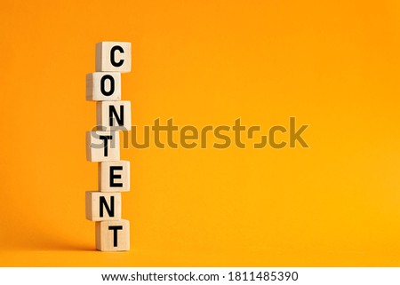 The word content on stacked wooden cubes with yellow background. Content creation or management in business information technologies.