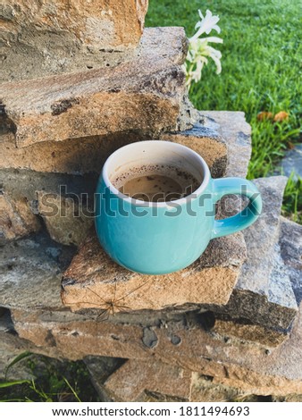 Blue cup of coffee in stones 