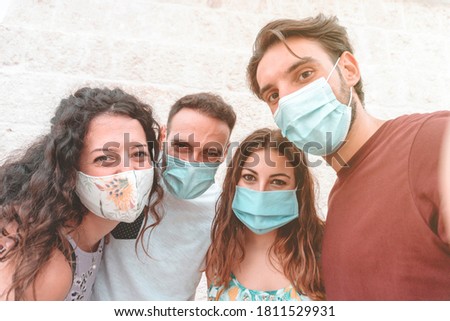 Friends group having fun taking a selfie and wearing the surgical mask