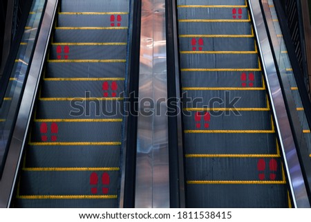 sticker foot print for keep social distancing symbol on escalator of new normal behavior for safty first in covid-19 coronavirus pandemic in office building or modern trade in urban lifestyle 