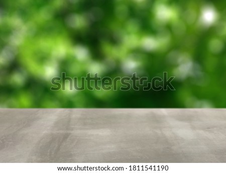 Cement surface in front of green tree with depth of field.On blurred background