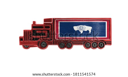Toy truck with State of Wyoming flag shown isolated on white background. The concept of cargo transportation between countries.