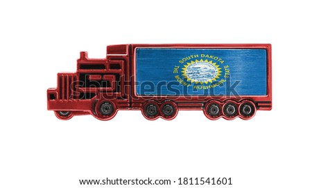 Toy truck with State of South Dakota flag shown isolated on white background. The concept of cargo transportation between countries.