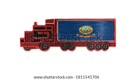 Toy truck with State of Idaho flag shown isolated on white background. The concept of cargo transportation between countries.