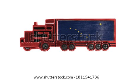 Toy truck with State of Alaska flag shown isolated on white background. The concept of cargo transportation between countries.