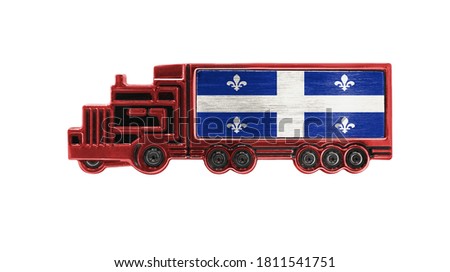 Toy truck with Quebec flag shown isolated on white background. The concept of cargo transportation between countries.